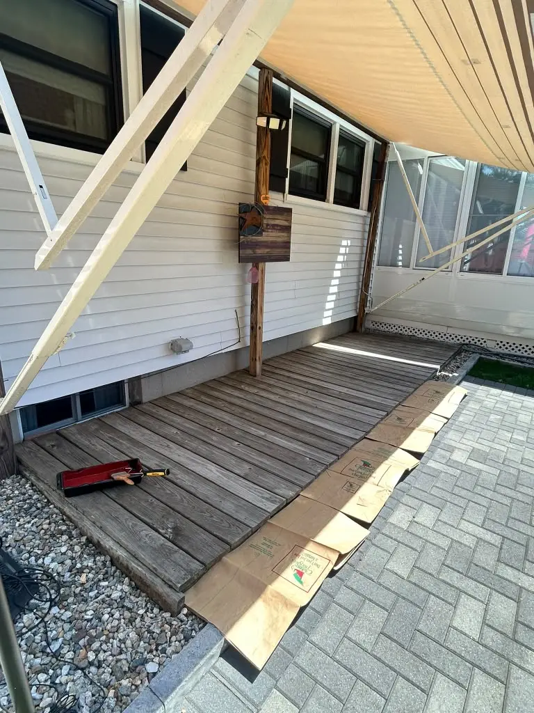 Side by side comparison of a smooth gray concrete driveway and a black asphalt driveway at a New England home